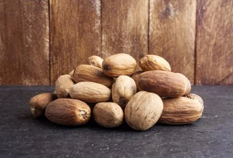 Nutmeg on dark stone table Stock Photos