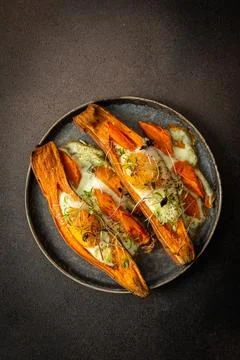 Nutrient-rich eggs baked inside sweet potatoes sit on a rustic plate. Fresh m Fotos Stock
