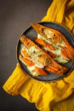 Nutrient-rich eggs baked inside sweet potatoes sit on a rustic plate. Fresh m Stock Photos