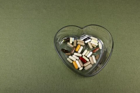 Nutritional Supplements in a Heart Shape Clear Glass Dish Foto stock