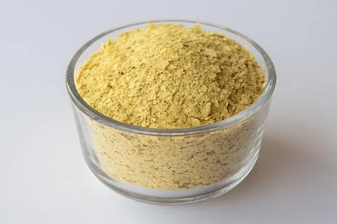 Nutritional yeast in a bowl on withe background Stock Photos