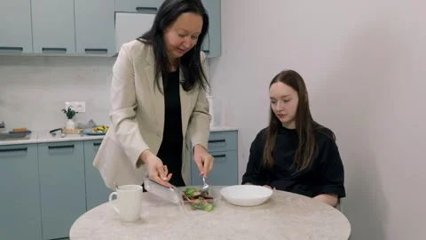 Nutritionist serving a portion of vegetables to young patient during a Video stock 306989056