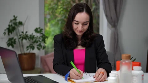 Nutritionist thoughtfully taking notes while working with dietary products Stock Footage 299578719