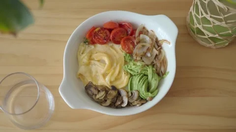 Nutritious breakfast bowl featuring eggs and a variety of vegetables Stock Footage 346877307