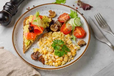 Nutritious breakfast, brunch. Scramble eggs, grilled vegetables and rye bread Stock Photos