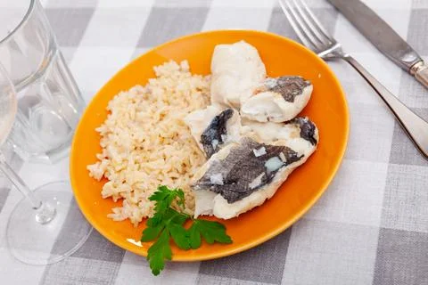 Nutritious meal of baked cod fish fillets with basmati rice and greens Stock Photos