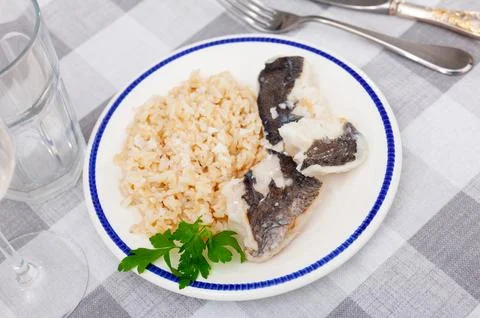 Nutritious meal of baked cod fish fillets with basmati rice and greens Stock Photos