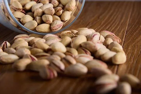 Nutritious nuts in hard shells sprinkled on table from overturned glass dishes Stock Photos