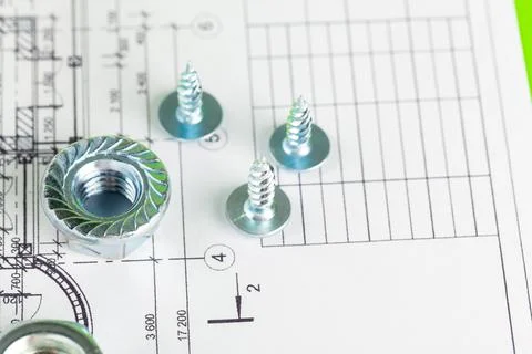 Nuts and bolts close-up over house plan 库存照片