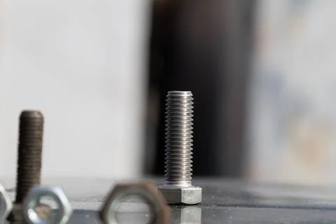 Nuts and Bolts on a Work Surface in a Light Background Showing Tools Used i.. Stock Photos