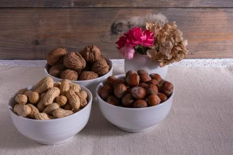 Nuts and flowers stand on the table. Stock Photos