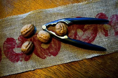 Nuts and a nutcracker are on a linen napkin. Stock Photos