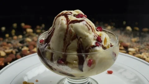 Nuts Are Sprinkled Over Ice Cream on Black Background Stock-Footage 120358539