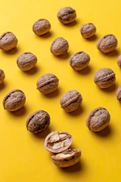 Nuts arranged in rows with a yellow background. Stock Photos