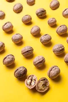 Nuts arranged in rows with a yellow background. Stock Photos