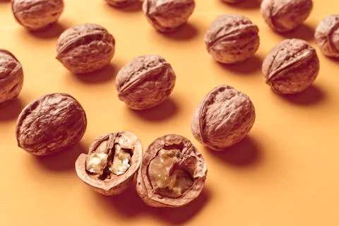Nuts arranged in rows with a yellow background. Stock Photos