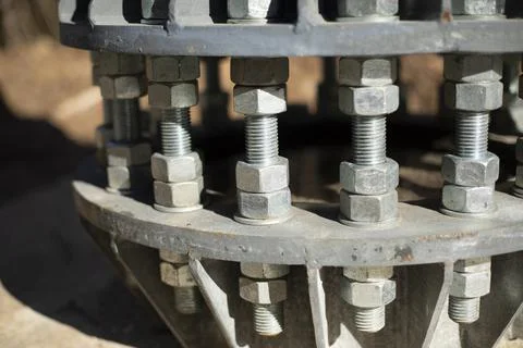 Nuts on bolts. Base of communication pole. Steel structural elements. Stock Photos