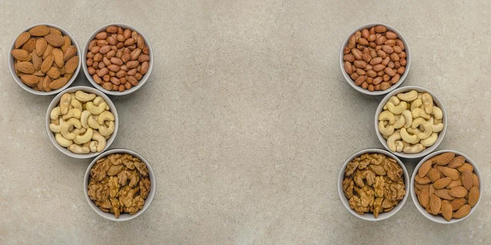 Nuts of different varieties, top view. The mixed nuts lie in bowls on a stone Stock Photos