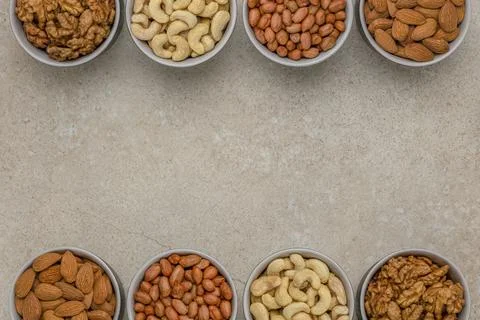 Nuts of different varieties, top view. The mixed nuts lie in bowls on a stone Stock Photos