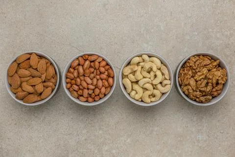 Nuts of different varieties, top view. The mixed nuts lie in bowls on a stone Stock Photos
