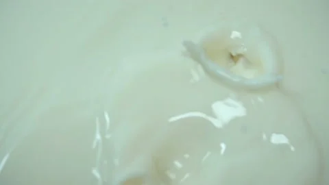 Nuts fall in slow motion into milk. Stock Footage 130840801
