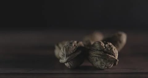 Nuts filmed in slow motion with a dark mood on a wooden background. Stock Footage 172155003
