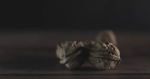 Nuts filmed in slow motion with a dark mood on a wooden background. Stock Footage 172155058