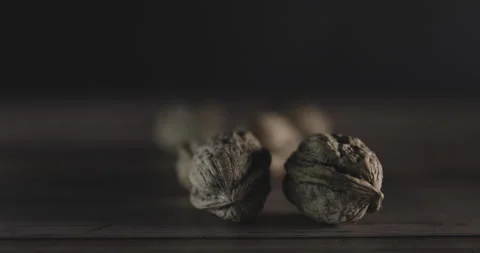 Nuts filmed in slow motion with a dark mood on a wooden background. Stock Footage 172155416