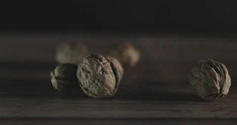 Nuts filmed in slow motion with a dark mood on a wooden background. Stock Footage 172155571