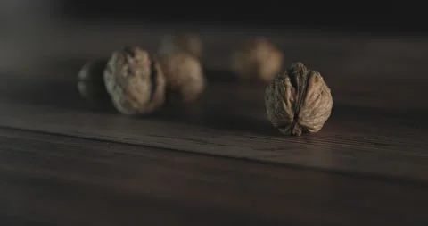 Nuts filmed in slow motion with a dark mood on a wooden background. Stock Footage 172155908