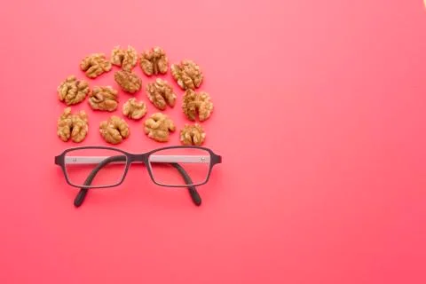 Nuts with glasses on a red background Stock Photos