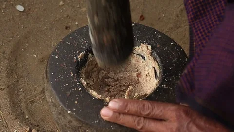 Nuts is grinded in a stone mortar in yard, Bagan. Myanmar, Burma Stock Footage 75021044