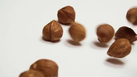Nuts of hazelnut fall on a white table. Slow motion. Stock Footage 88824622