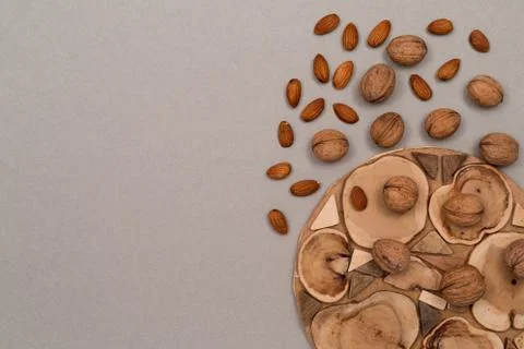Nuts, inshell walnuts, peeled almonds, sprinkled on a table, craft paper and  Stock Photos