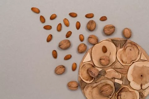 Nuts, inshell walnuts, peeled almonds, sprinkled on a table, craft paper and Stock Photos