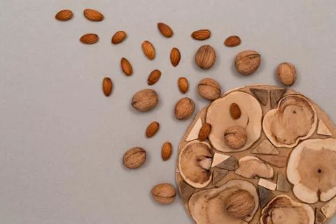 Nuts, inshell walnuts, peeled almonds, sprinkled on a table, craft paper and Stock Photos