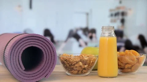 Nuts, juice, apple, against the background of sports women,Yoga class Video stock 74456385