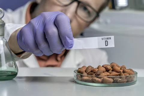 Nuts on a laboratory table with the name of vitamin. Essential vitamins. Doct Stock Photos