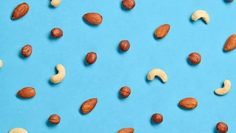 Nuts mix colorful pattern on blue background. Fitness vitamin composition. .. Stock Photos