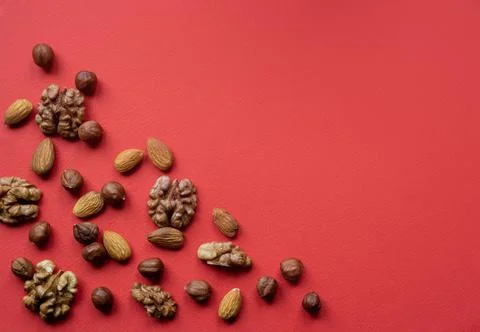 Nuts scattered flat lay on red background 스톡 사진