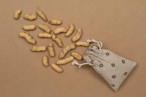 Nuts, shelled peanuts, sprinkle on the table from a linen bag, kraft paper Stock Photos