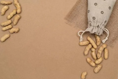Nuts, shelled peanuts, sprinkle on the table from a linen bag, kraft paper Stock Photos