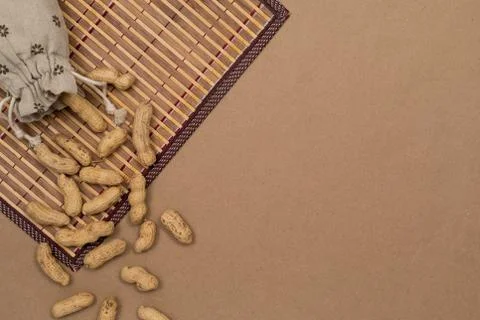 Nuts, shelled peanuts, sprinkle on the table from a linen bag, kraft paper Stock Photos