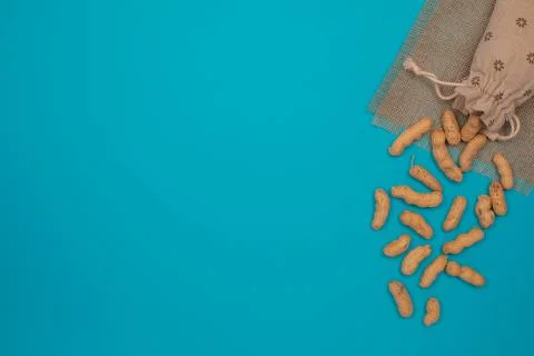 Nuts, shelled peanuts, sprinkle on the table from a linen bag, colored Stock Photos