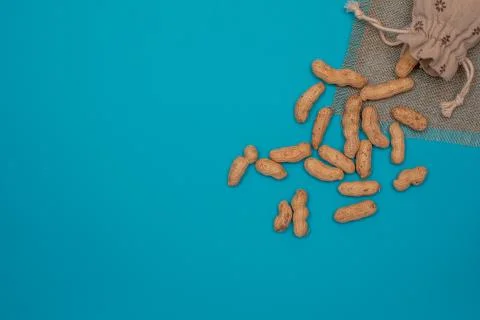 Nuts, shelled peanuts, sprinkle on the table from a linen bag, colored Stock Photos