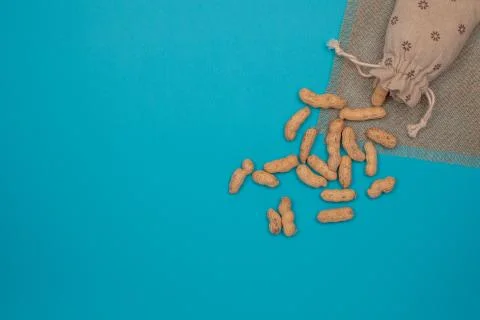 Nuts, shelled peanuts, sprinkle on the table from a linen bag, colored Stock Photos