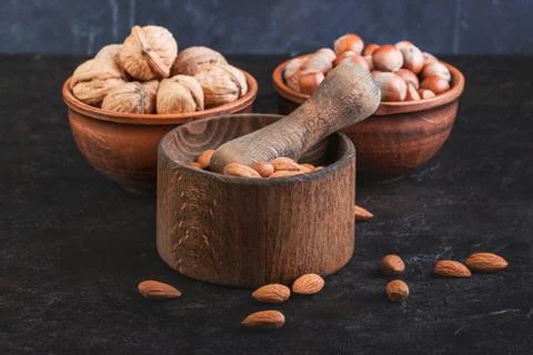 Nuts, walnuts, almonds and hazelnuts in utensils and mortar Stock Photos
