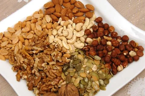 Nuts on a white plate Stock Photos