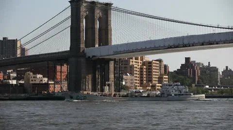 NY transporting goods on boat under Brooklyn bridge 動画素材 10559601