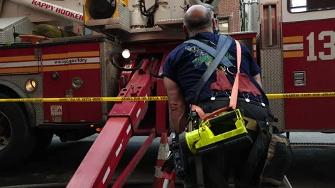 NYC FDNY Firefighter examines angle of Firetruck with Survey level kit Stock Footage 134205908